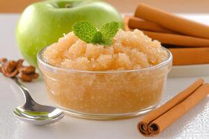 A bowl of sugar and cinnamon next to an apple photo