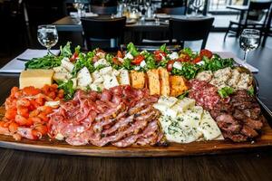 A platter of meat and cheese on a wooden table photo