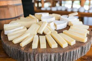 A wooden table topped with cheese and other food photo