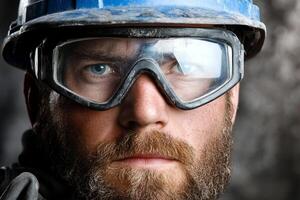 A man with a beard and goggles in a hard hat photo