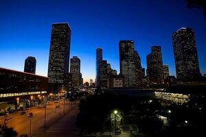 A city skyline at dusk with a few buildings in the background photo