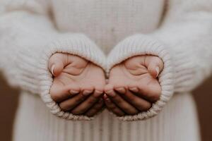 A person in a sweater is holding their hands out photo
