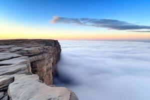 A cliff with a view of the clouds above photo