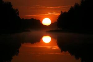 The sun is setting over a river photo