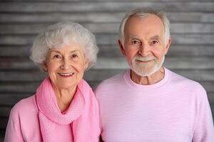 An older couple in pink shirts posing for the camera photo