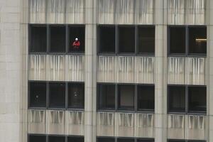 A man is seen on the ledge of a building photo