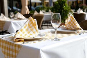 A table with a white tablecloth and yellow checkered napkins photo