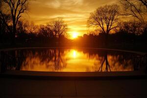 A sunset over a pond with trees in the background photo