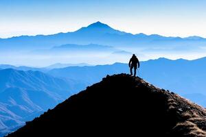 A person standing on top of a mountain with the mountains in the background photo