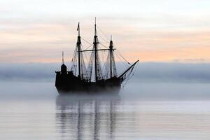 A tall ship in the fog on the water photo
