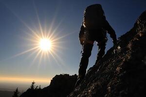 A person climbing up a mountain with the sun in the background photo