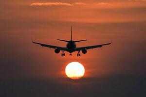 An airplane is flying in the sky at sunset photo