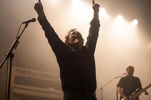 A man with his hands up in the air on stage photo