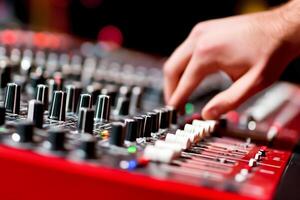 A person is playing a sound mixer on a red instrument photo