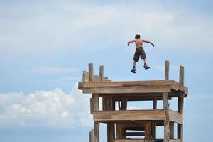 A man jumping off of a wooden structure photo