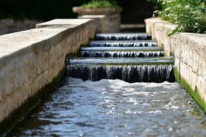 A stream of water flowing down a stone wall photo