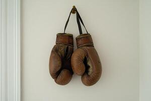 Two old boxing gloves hanging on a wall photo