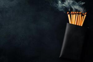 Matches in a Black Case With Smoke Rising in a Dimly Lit Background photo