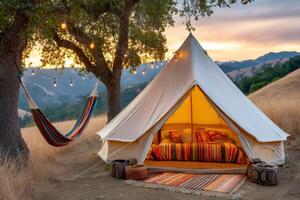 Illuminated tent and hammock under trees at sunset in a glamping site photo