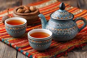 Moroccan tea set with two cups and nuts on a colorful rug photo