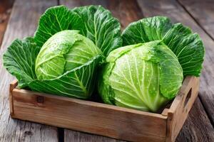 Fresh green cabbages with water drops sitting in wooden crate on rustic table photo