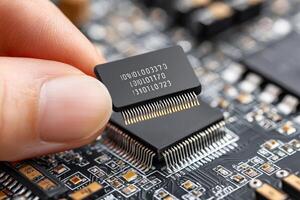 Technician installing microchip on motherboard, close up of electronic components photo