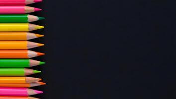 Neon Colored Pencil Stack on Left Edge with Black Background photo