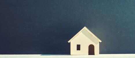 Simple wooden house model on a dark background photo