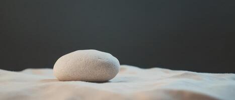 Smooth stone on fabric in soft light photo