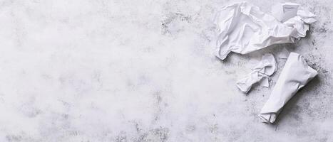 Crumpled white paper on textured gray surface photo