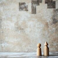 Wooden figures stand against a textured wall photo