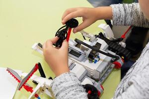 Children are working on model assembly in robotics class. Education photo