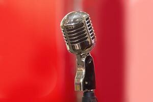 Vintage microphone on stage on a red background photo