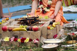 Krishnaids with fruit by the fire during the ritual photo