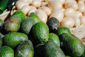 avocados, potatoes, and other vegetables are displayed in baskets photo