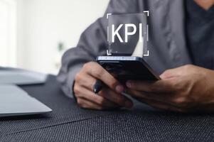 Man Using Smartphone to Track Key Performance Indicators Effectively photo