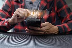 Hands Interacting with Smartphone Displaying API Programming Concept photo