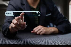 Man in Suit Touching Virtual Search Bar Display on Table photo