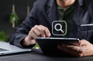 Man Using Tablet with Search Icon for Information Online photo