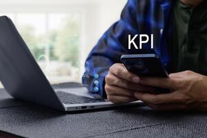 Businessman Analyzing KPI Performance with Laptop and Smartphone photo