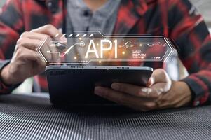 Person Using Tablet with API Interface Graphic Overlay photo