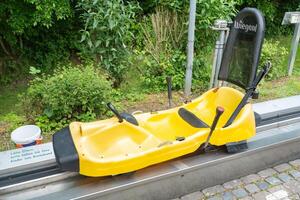 Homberg, Germany, 06.09.25. Bright Yellow Summer Toboggan on a Track photo