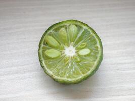 Close-up of a Freshly Sliced Green Citrus Fruit with Visible Seeds and Juicy Pulp photo