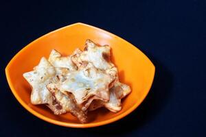 A bowl of Aloo Puff Pastry topped with a star-shaped design and served with tomato sauce. photo