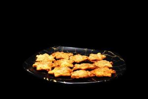 Elegant Golden Aloo Puff Stars on Sleek Black Marble - A Delight for Holiday Gatherings photo