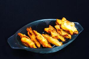 A clear glass bowl brimming with golden fried chicken wings, showcasing their delicious, crispy texture. photo