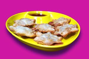 Crisp and Buttery Star Aloo Puffs Resting on Sleek Black Marble with Savory Tomato Kick - A Stunning Appetizer for Any Gathering, Isolated on Pink BG photo
