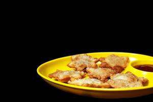 Delicate Starry Aloo Puffs Resting on Glossy Black Marble with Velvety Tomato Sauce - A Must-Have Gourmet Snack photo