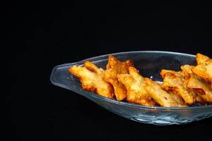 A glass bowl overflowing with fried chicken wings, featuring a crunchy exterior and rich, flavorful appearance. photo