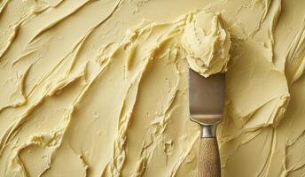 Butter texture with knife, top view and yellow background, copy space photo